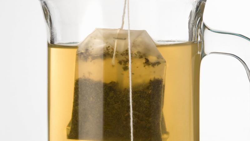 o cana de ceai transparenta cu un pliculet de ceai in ea