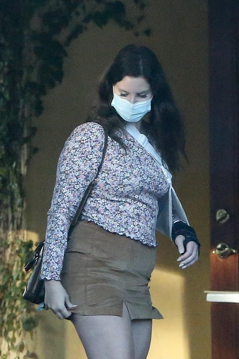 Lana Del Rey, cu mâna în ghips, mască de protecție, fustă mini și o bluză înflorată, în parcarea unui restaurant