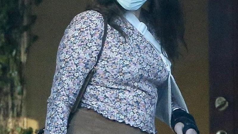 Lana Del Rey, cu mâna în ghips, mască de protecție, fustă mini și o bluză înflorată, în parcarea unui restaurant