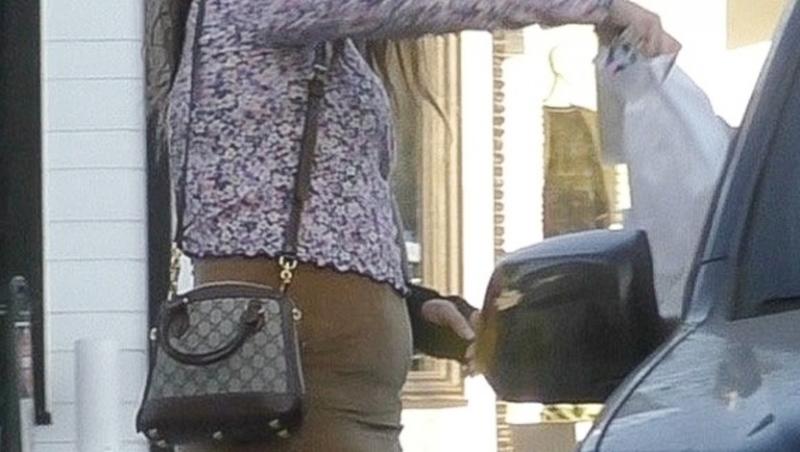 Lana Del Rey, cu mâna în ghips, mască de protecție, fustă mini și o bluză înflorată, se pregătește să urce în mașina personală