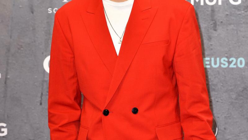 Liam Payne, privește direct în obiectivul aparatului de fotografiat și este îmbrăcat cu un sacou roșu, cu două rânduri de nasturi