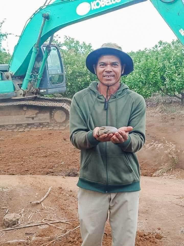 un muncitor din cambodgia cu broasca taur in mana