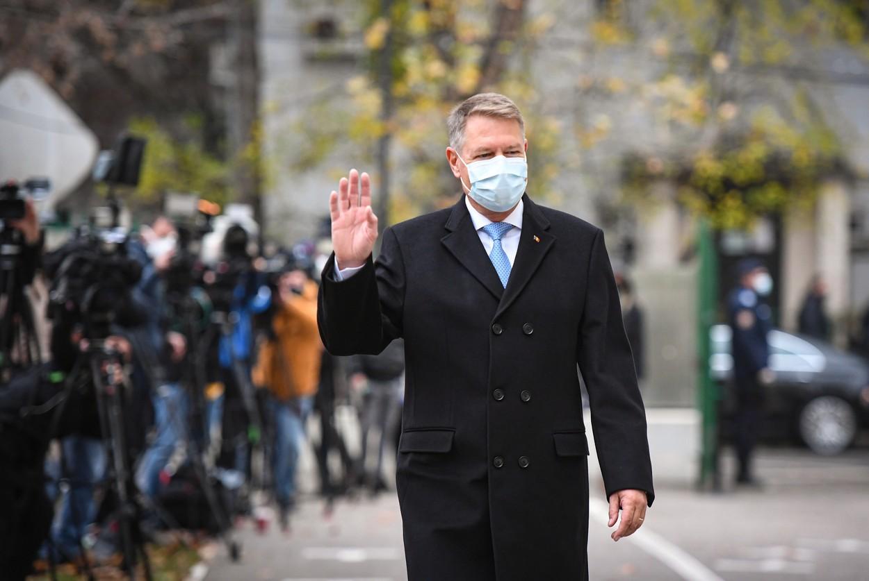 Klaus Iohannis, purtând mască de protecție și un palton negru