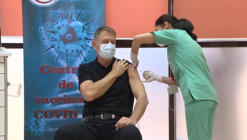 Klaus Iohannis, într-un tricou negru, în timpul vaccinului