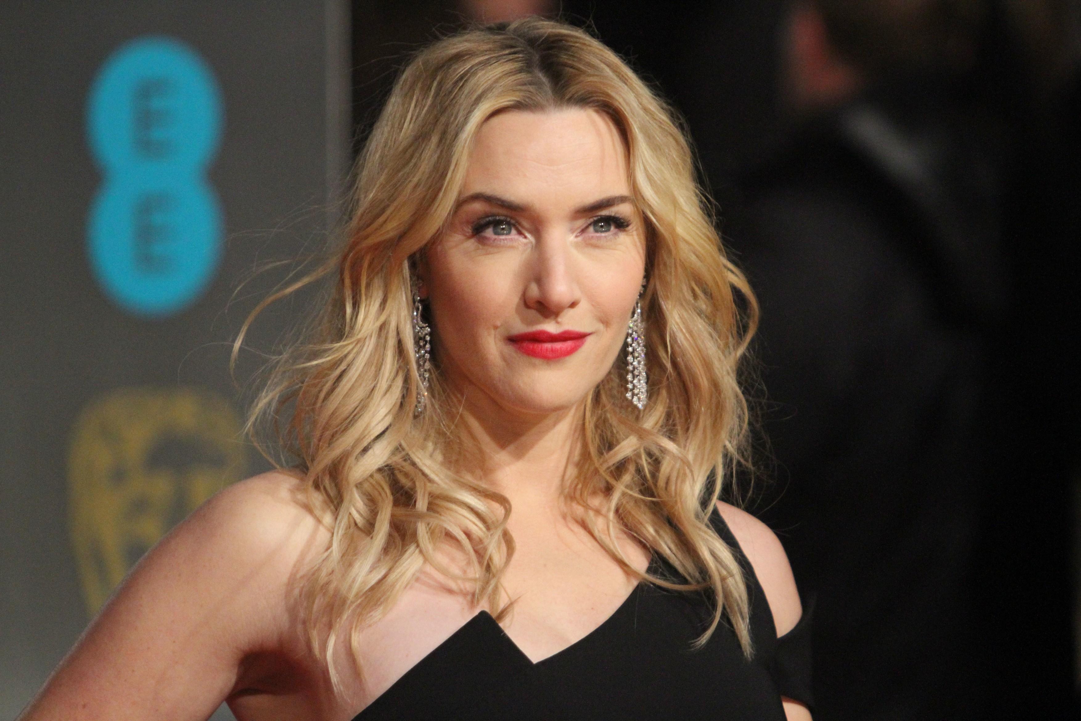 Kate Winslet, covorul rosu, blonda, rochie neagra fara bretele