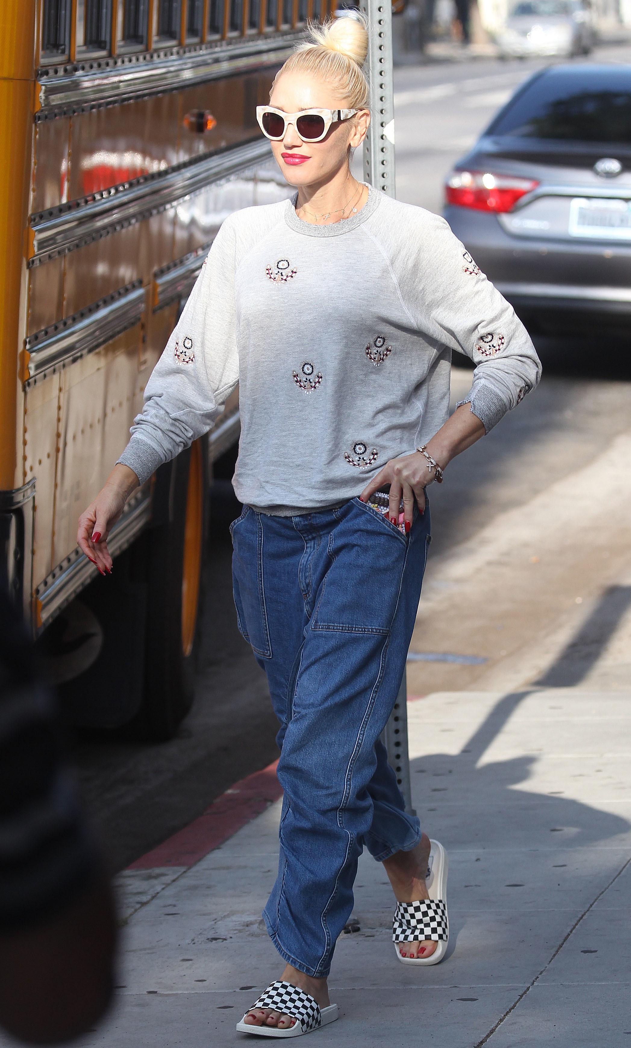 Gwen Stefani, pe strada, haine comode, bluza gri, pantaloni de culoare albastra