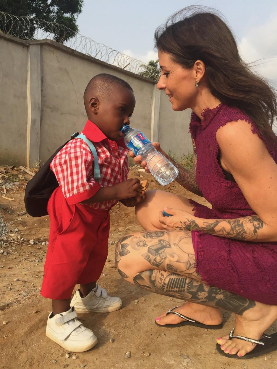 Hope, băiețelul din Nigeria abandonat să moară de foame, cu uniformă de școlar, primind apă de la Anja Loven
