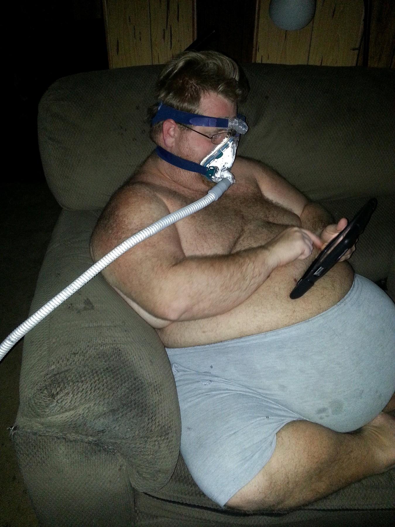 Zach Moore pe vremea când avea 226 kilograme, stând în haine de casă pe fotoliu, cu un aparat de oxigen la nas