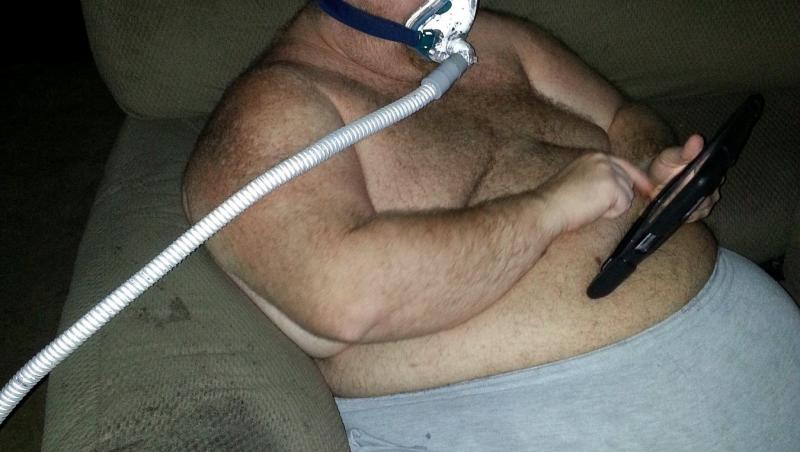 Zach Moore pe vremea când avea 226 kilograme, stând în haine de casă pe fotoliu, cu un aparat de oxigen la nas
