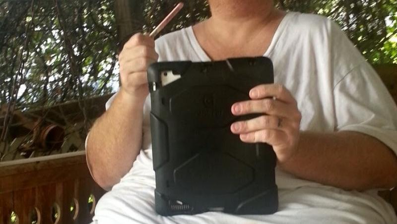 Zach Moore pe vremea când avea 226 kilograme, stând pe banca in curtea casei, cu tableta in maini