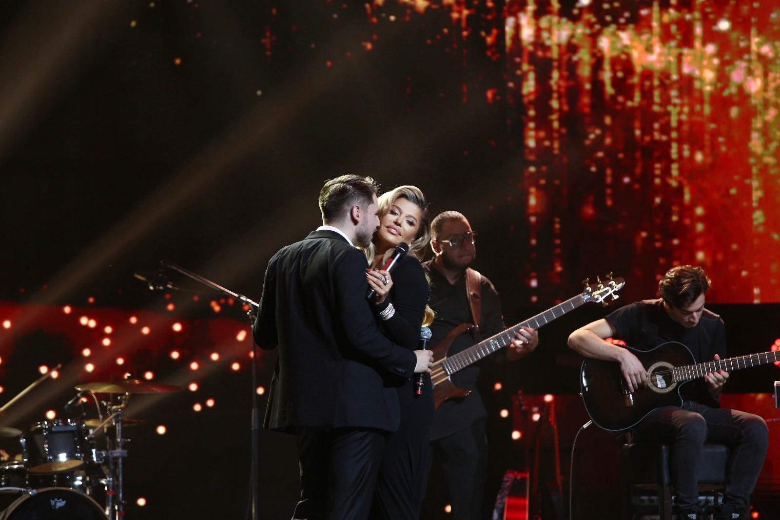 Loredana Groza într-o rochie neagră, decoltată, alături de Adrian Petrache, îmbrăcat la costum, pe scena X Factor 2020