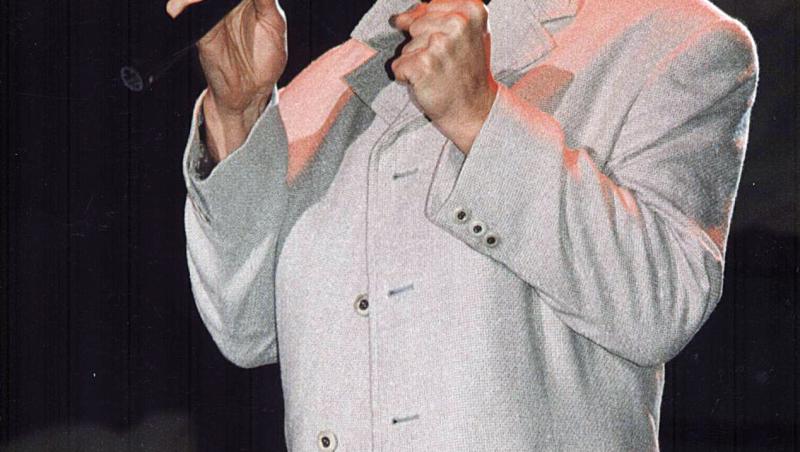 Gabriel Cotabiță, în tinerețe, pe scenă, într-un palton bej