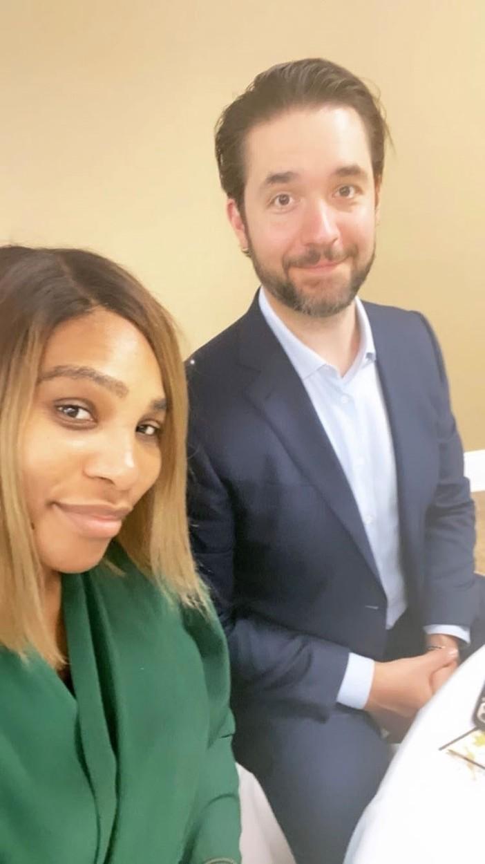 Serena Williams, într-o haină verde și soțul acesteia, într-un sacou negru