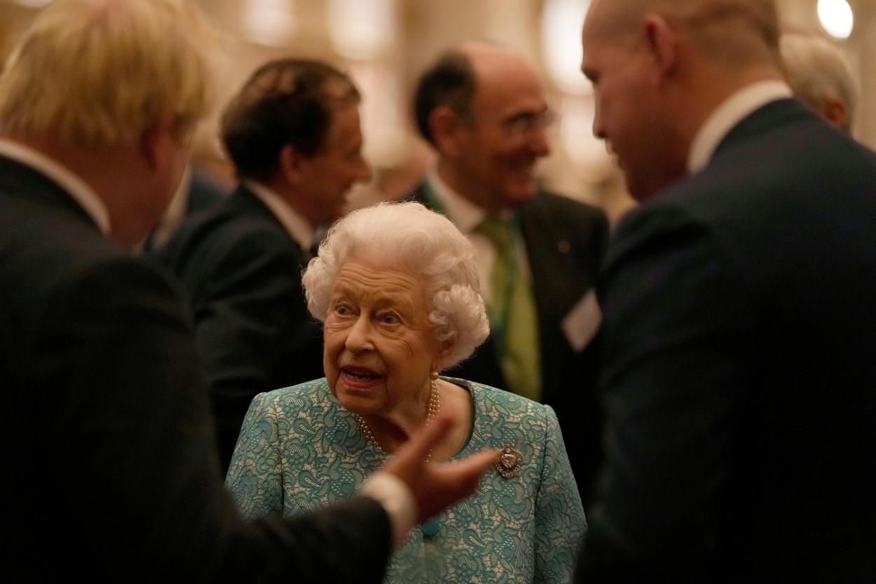 regina elisabeta a II-a sta de vorba cu un barbat care gesticuleaza