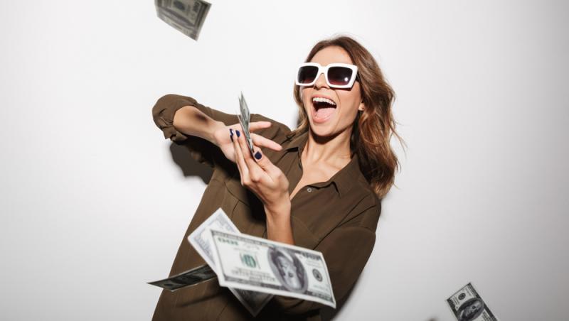 femeie cu ochelari de soare care arunca cu bani