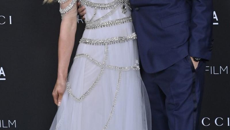 Paris Hilton imbracata intr-o rochie lunga eleganta il saruta pe carter reum care poarta un costum albastru