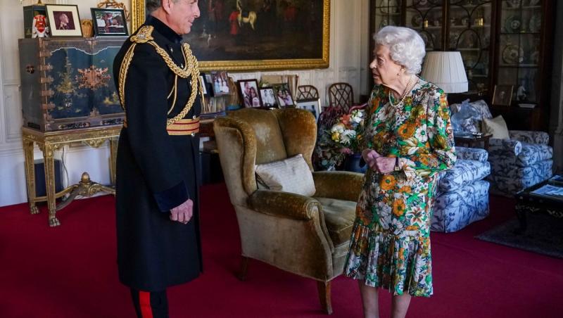 Regina Elisabeta a Marii Britanii împreună cu Sir Nick Carter, șeful  Statului Major al Apărării, purtand o rochie cu imprimeuri în tonuri de verde, maron și portocaliu