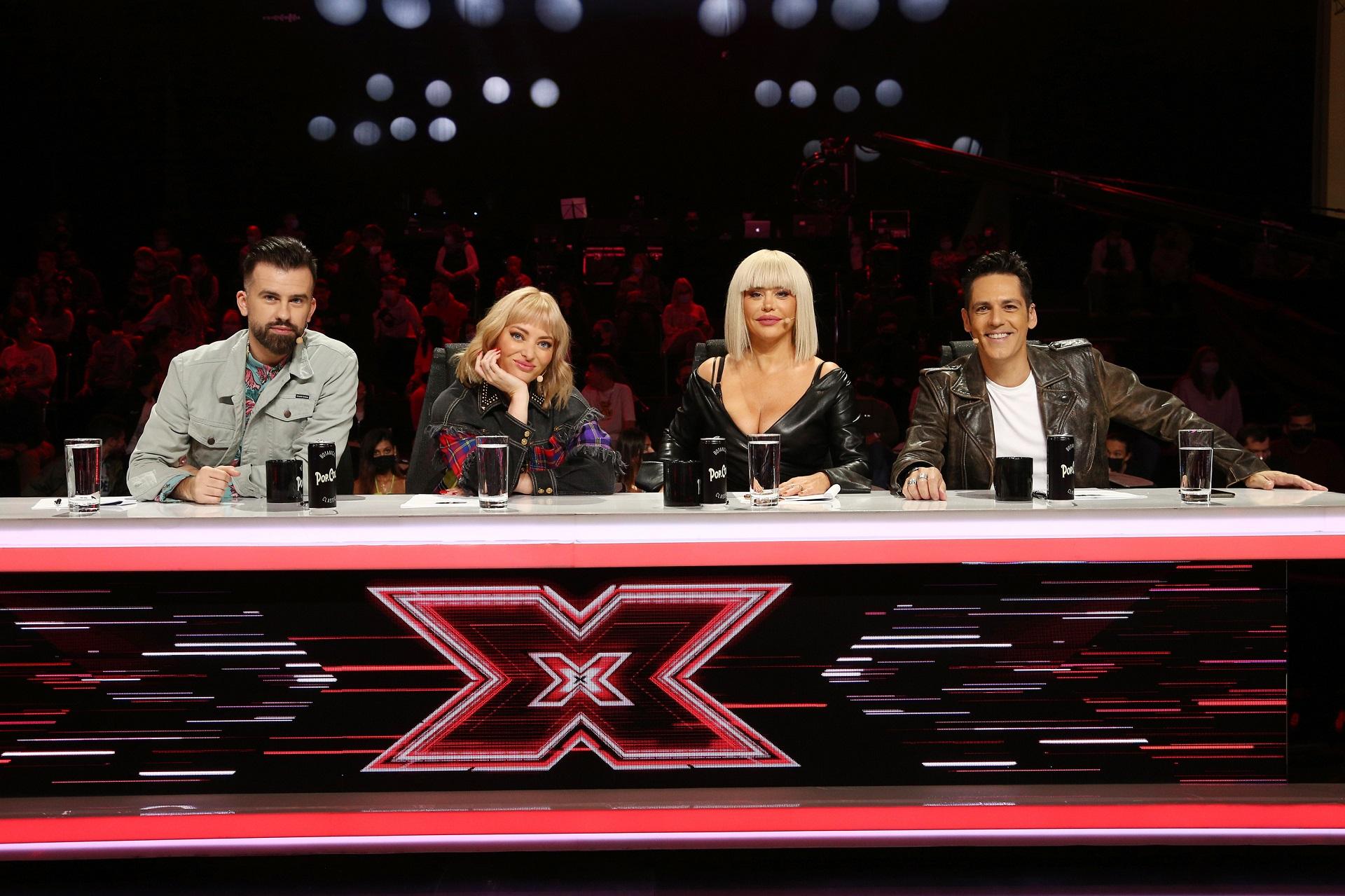 jurații X Factor 2021, florin ristei, delia, loredana și ștefan bănică, la mara juraților din sezonul 10 X Factor. Masa e cu negru și are un X roșu pe partea din față