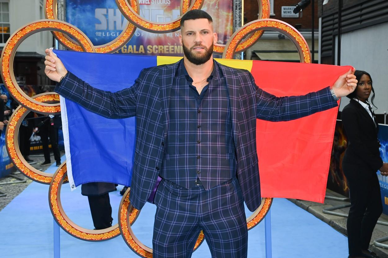 Florian Munteanu imbracat in costum si fluturand steagul romanesc
