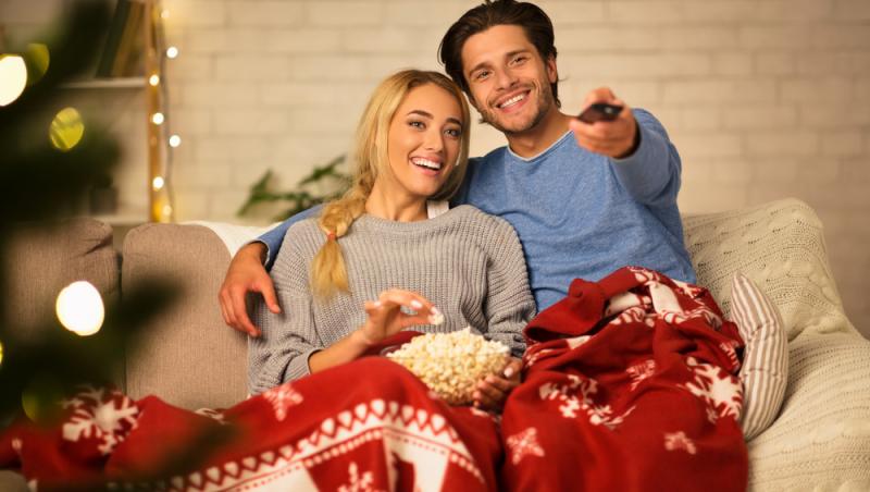 un-cuplu-într-o-pătură-cu-popcorn-și-telecomandă