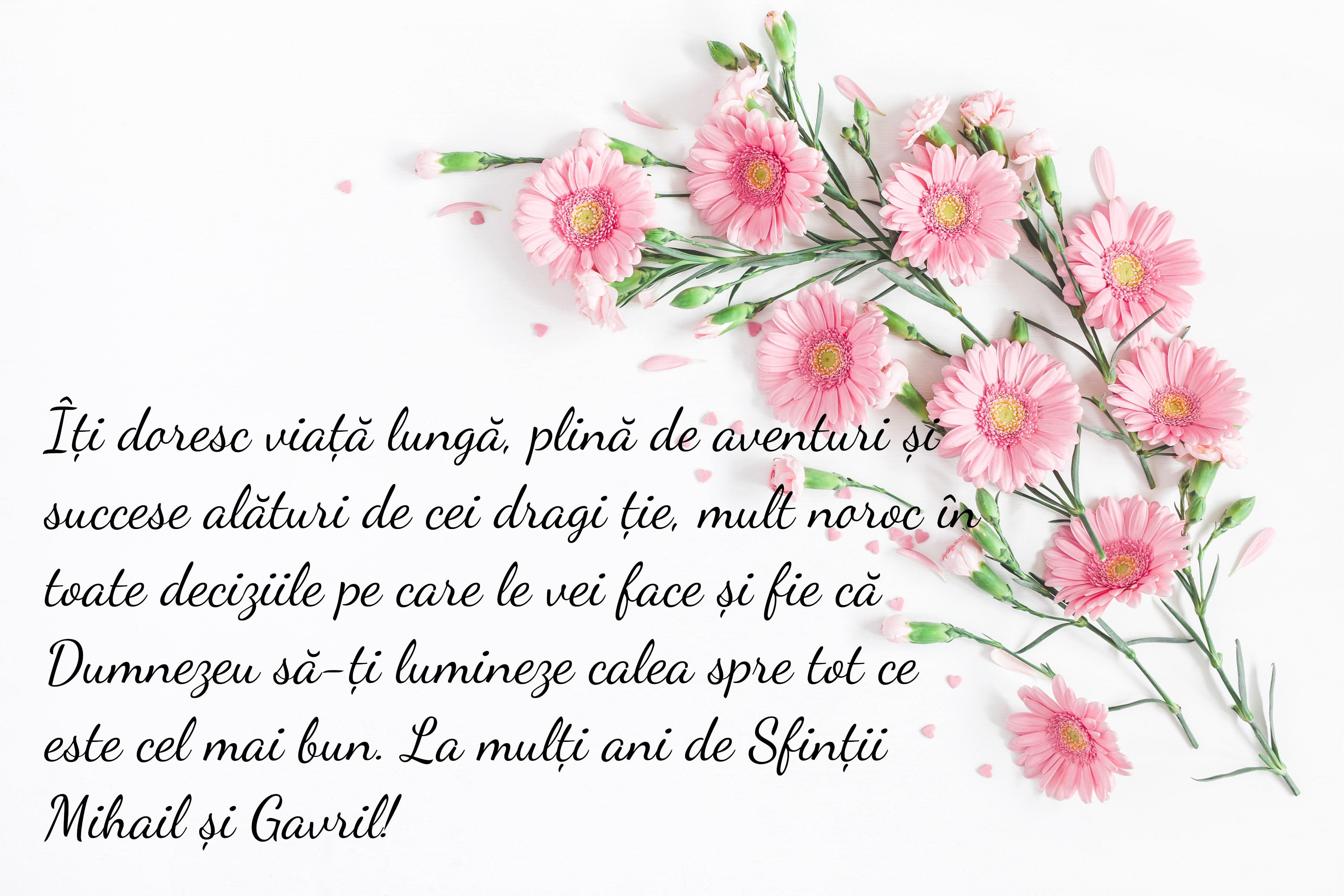 mesaj de la multi ani pe o felicitare alba cu flori roz