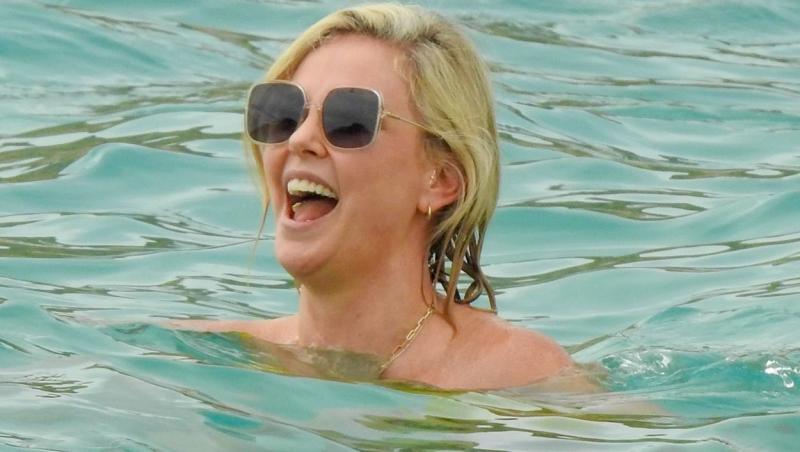 Charlize Theron in apa, cu ochelari de soare la ochi