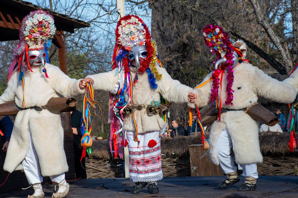 tineri costumati in masti traditionale de craciun in timp ce danseaza