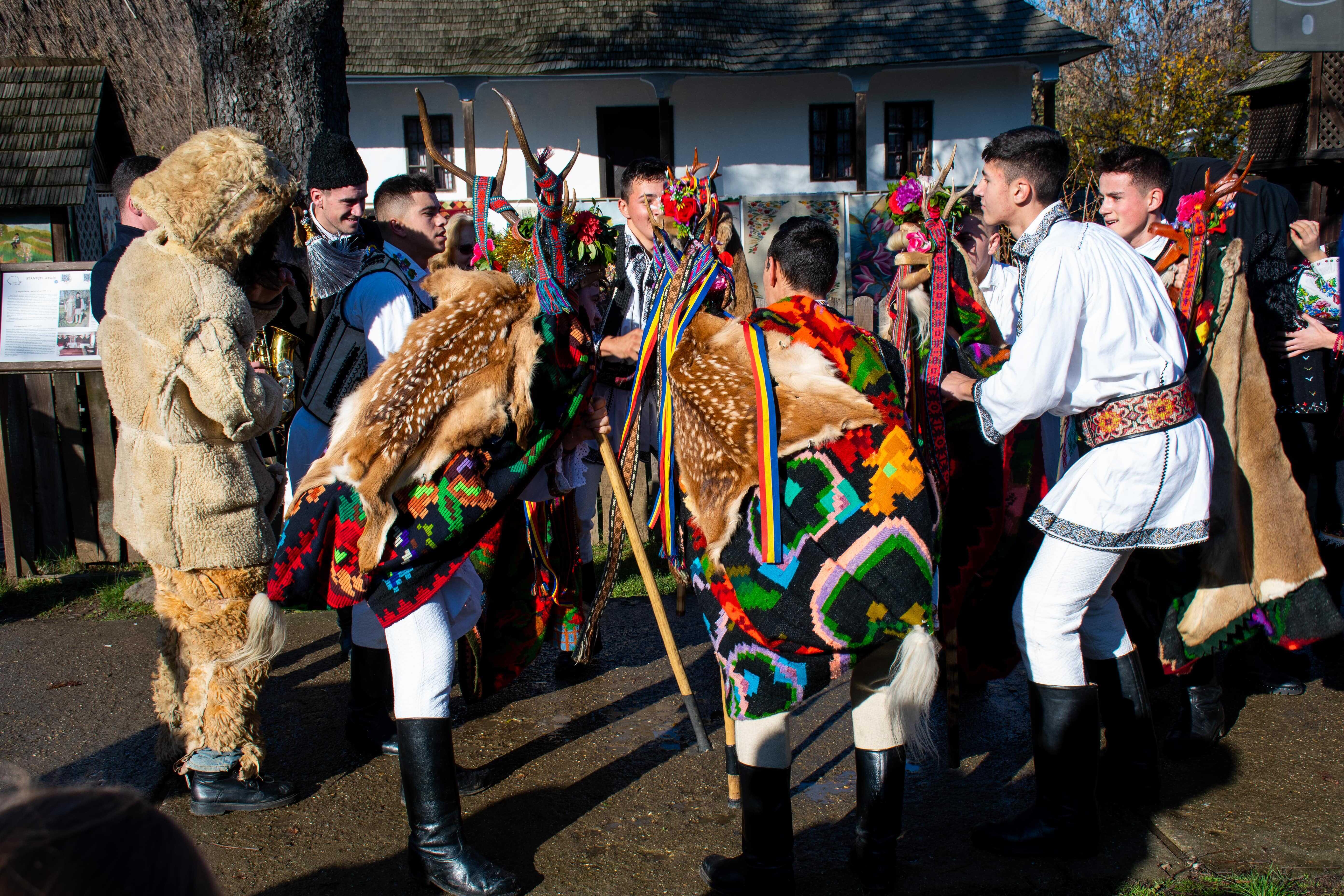 barbati si femei care danseaza imbracati in urs si costume traditionale specifice pentru revelion