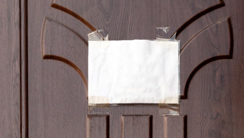 un bilet cu un mesaj lipit pe o usa