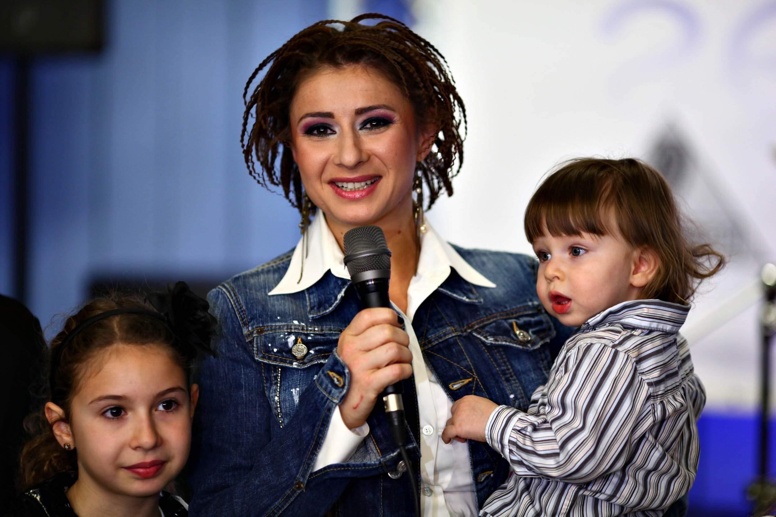 Anamaria Prodan  cu codite si cu copii in brate, la un eveniment public