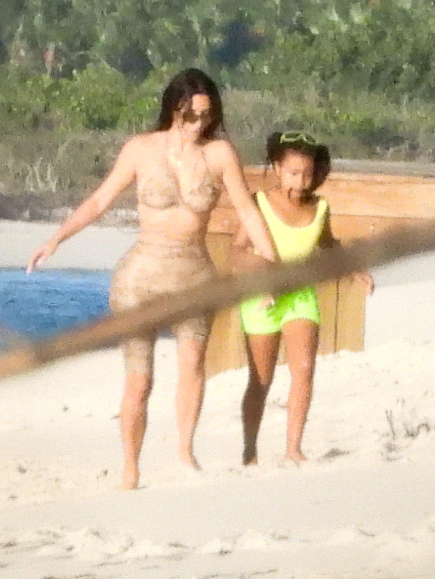 Kim Kardashian, plaja, langa un copil in costum verde