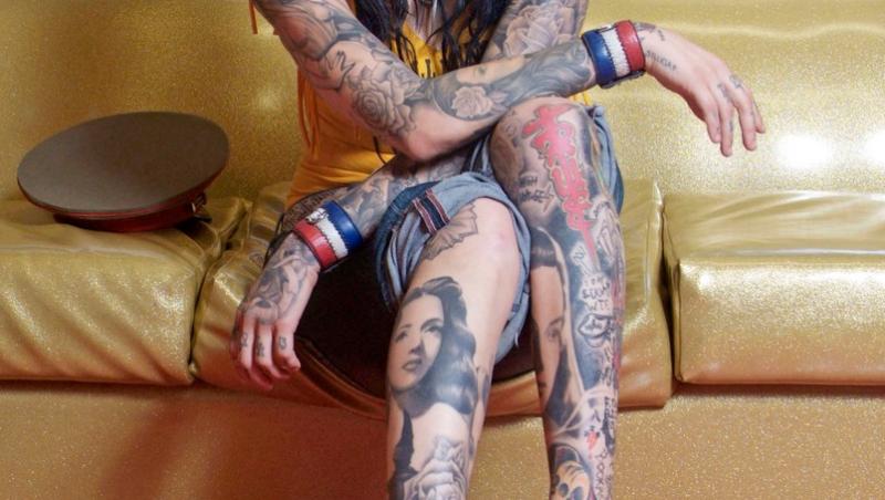 kat von d pe o canapea cu multe tatuaje la vedere