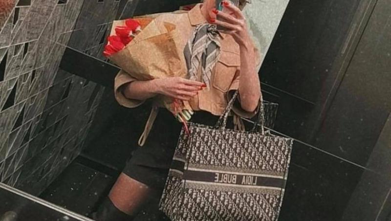 Lidia Buble în lift, are in mana geanta și un buchet de lalele