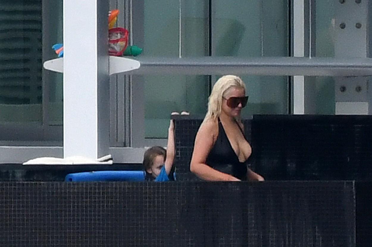 christina aguilera intr-un costum de baie negru in timp ce sta la piscina