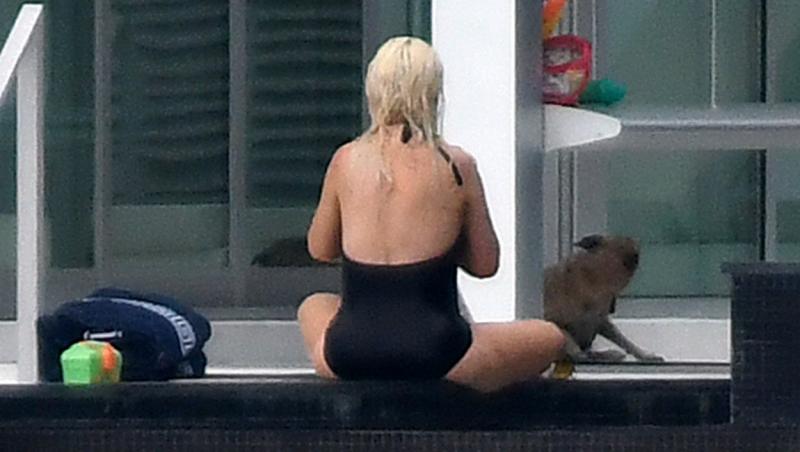 christina aguilera intr-un costum de baie negru in timp ce sta la piscina