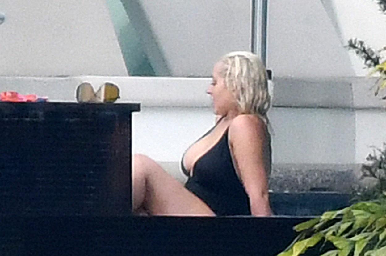 christina aguilera intr-un costum de baie negru in timp ce sta la piscina