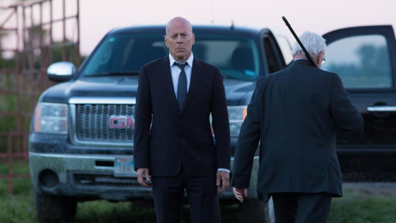 Bruce Willis, Death Wish, imbracat in negru, masina in spate