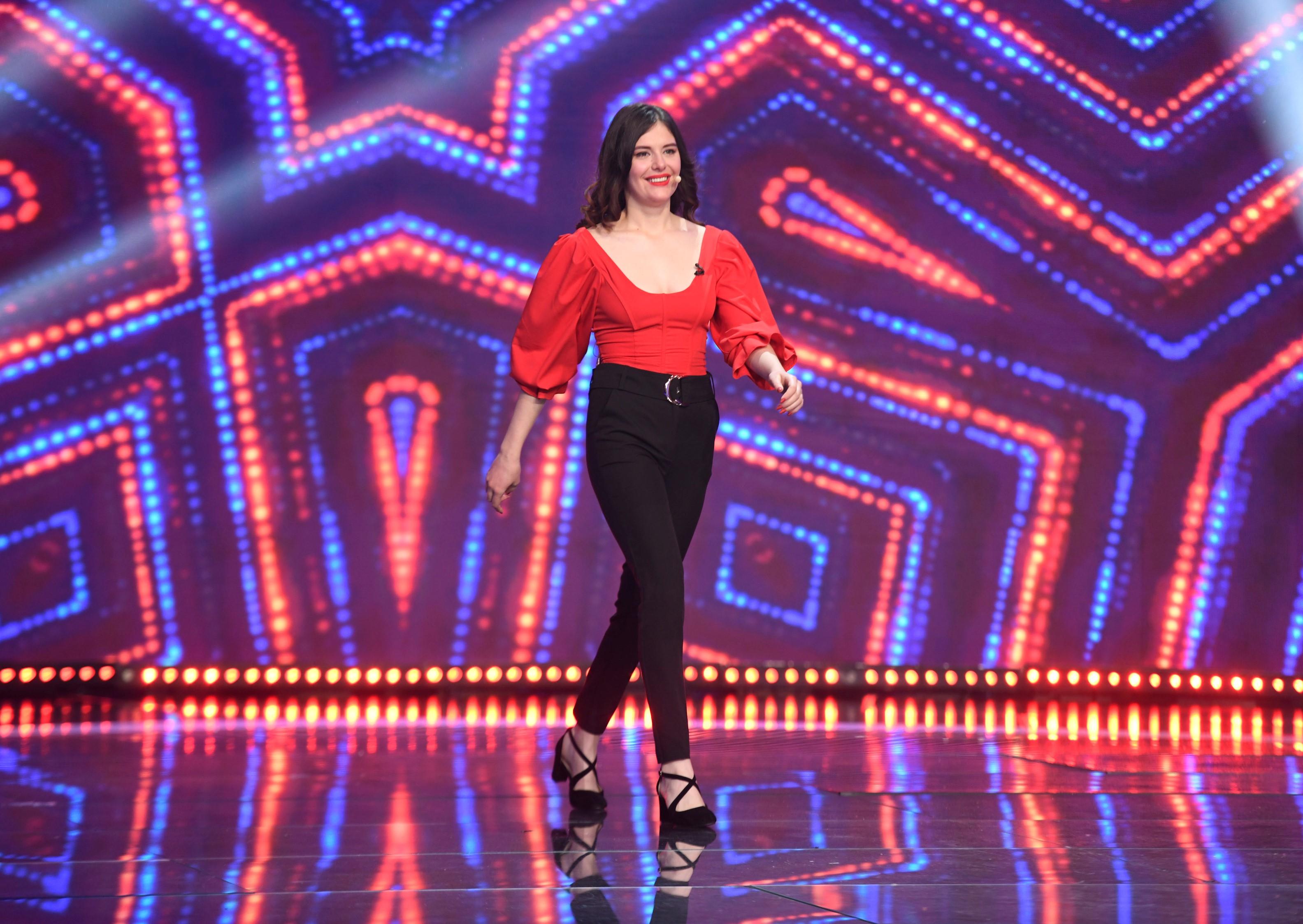 Ionela Irimescu intr-o bluza rosie si pantaloni negri, pe scena iUmor