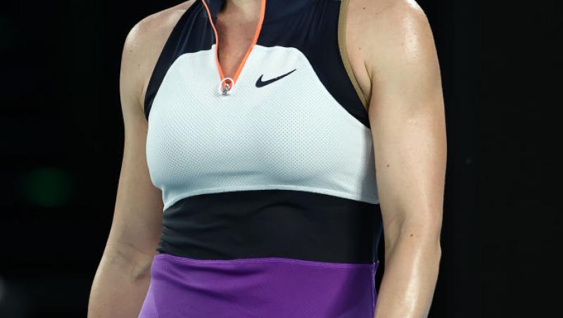 Simona Halep intr-o bluza alba si fusta mov, iar în mana tine paleta de tenis
