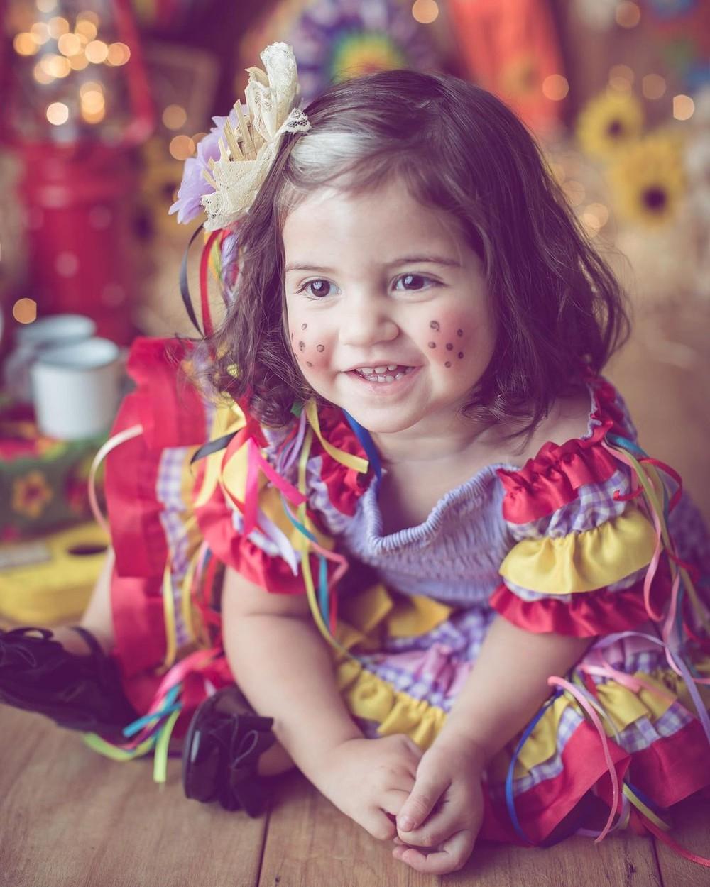 mayah la varsta de doi ani, imbracata cu o rochita mov cu rosu
