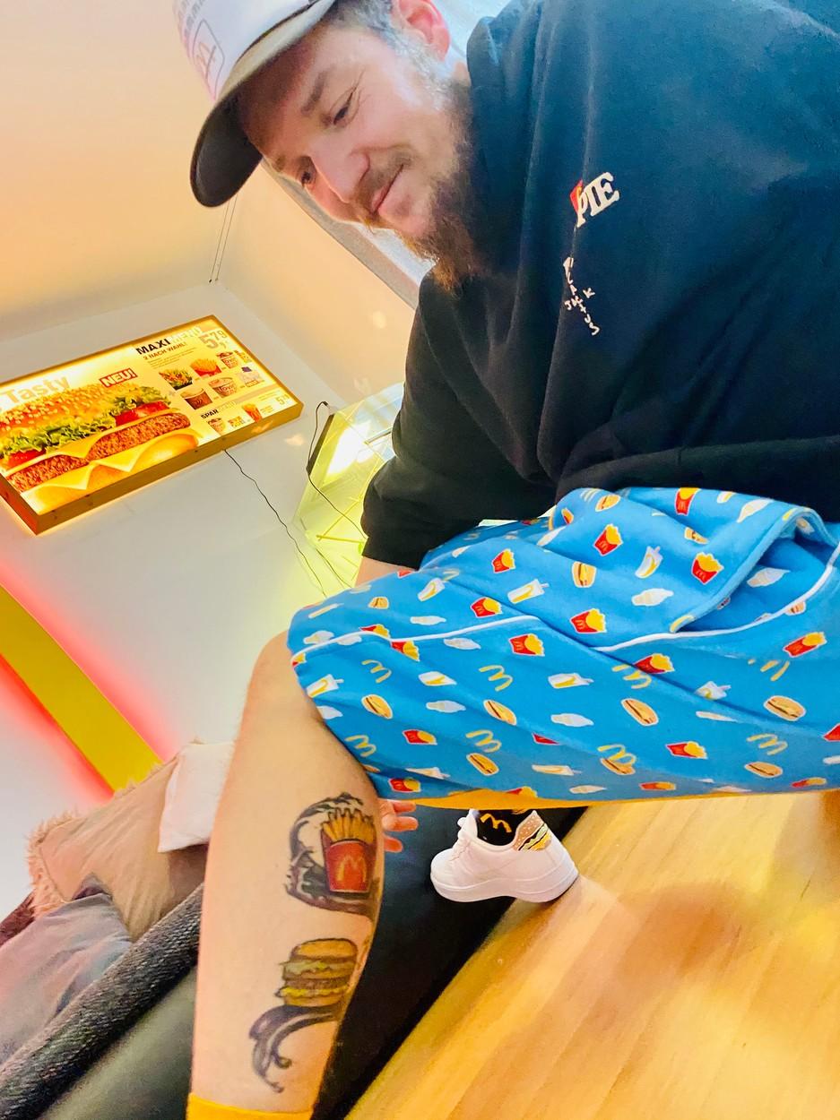 David Geyer acasă, arătându-și tatuajul cu burger și cartofi prăjiți