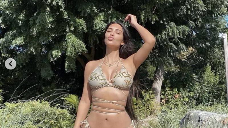 Kim Kardashian a purtat un costum de baie de culoare bej, cu imprimeu de șarpe, ce avea șnururi în jurul taliei.