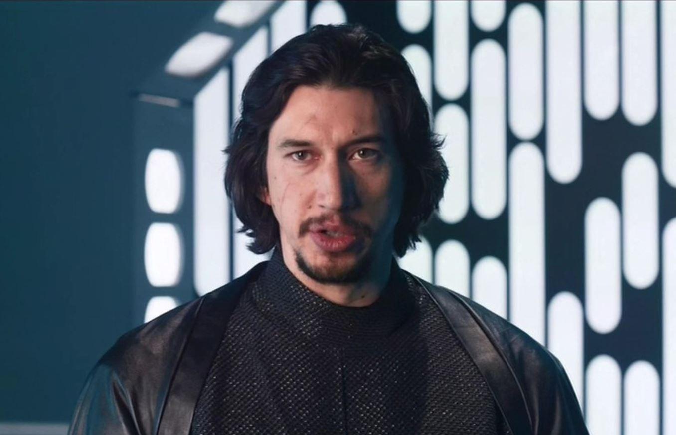 adam driver in rolul lui kylo ren imbracat in negru cu o sabie laser in mana