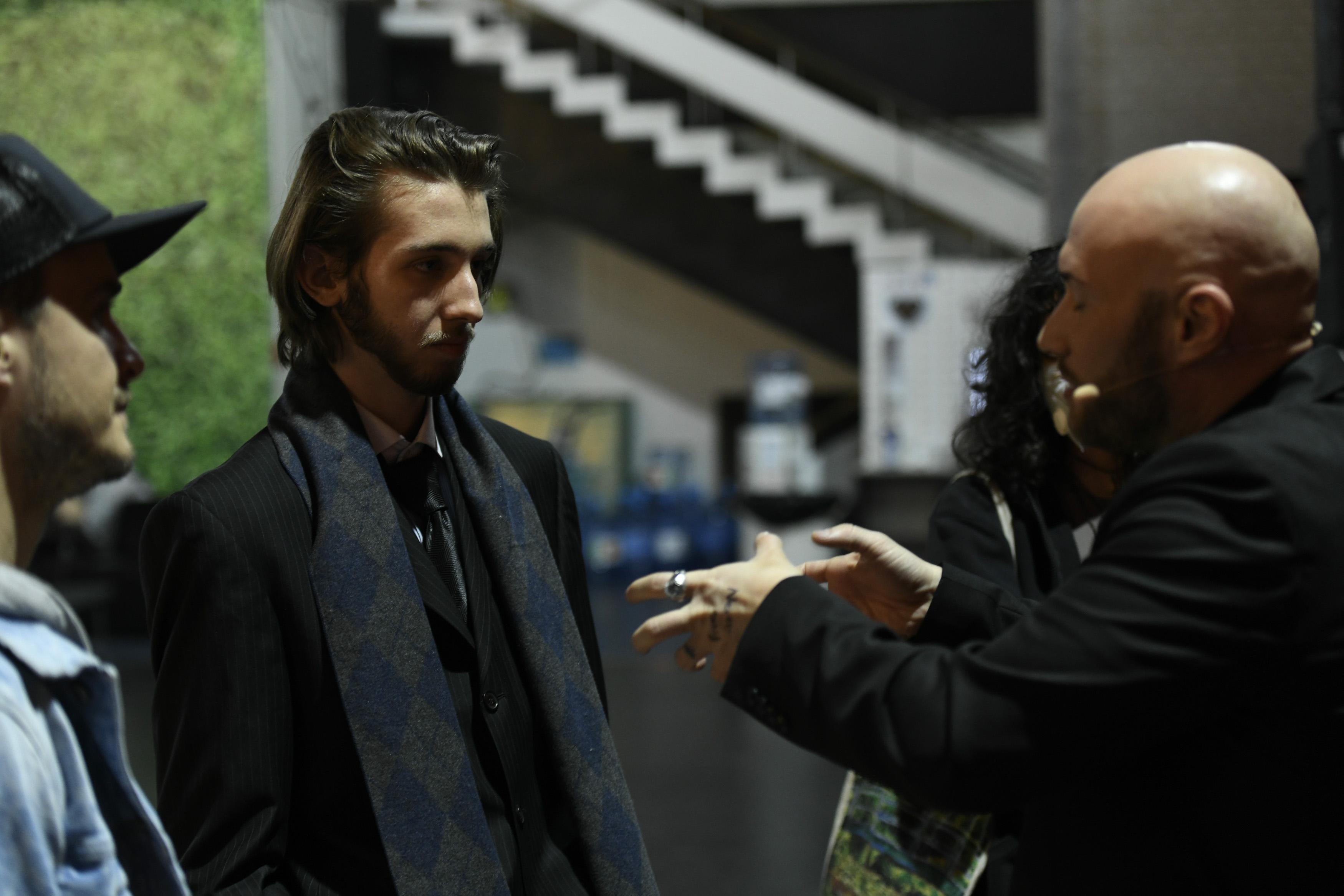 Luca Nicole pe scena iUmor într-un costum negru și Mihai Bendeac
