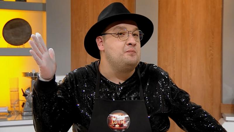 Răzvan Babană, gătind în bucătăria Chefi la cuțite, purtând pălărie și bluză cu paiete