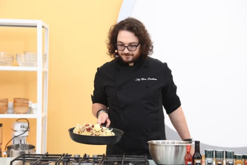 Florin Dumitrescu, în bucătăria Chefi la cuțite, ținând o tigaie în mână