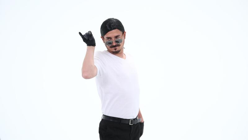 George Tănase într-un tricou alb și ochelari de soare, poarta perucă și mănuși negre