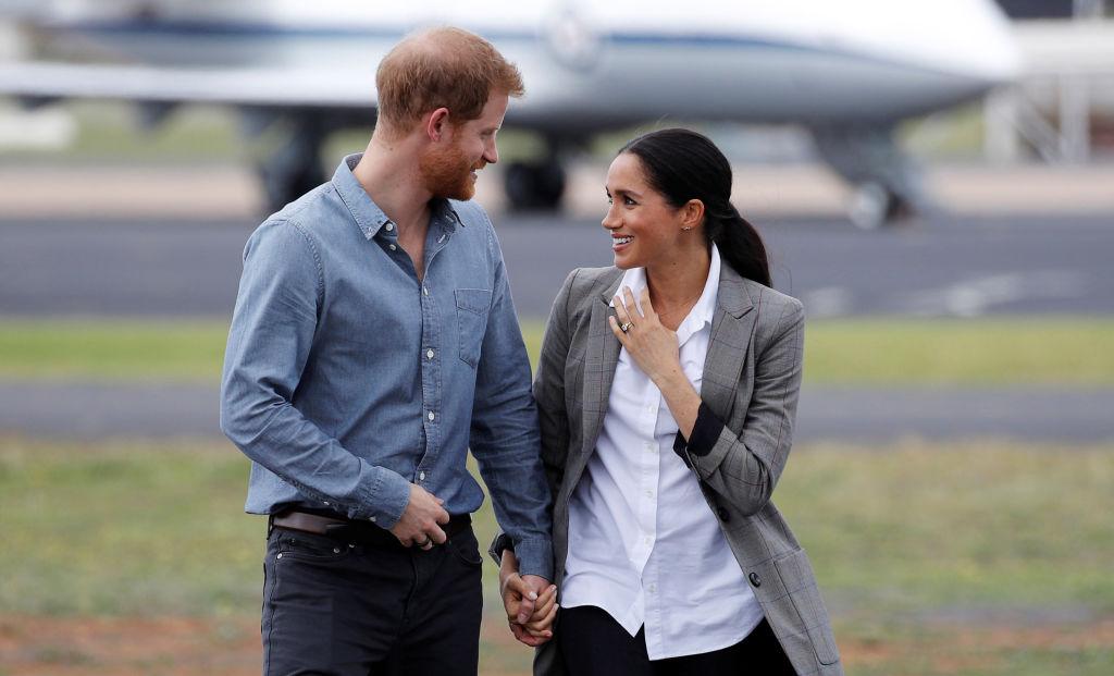 meghan markle in alb si un sacou cand il tine de mana pe printul harry