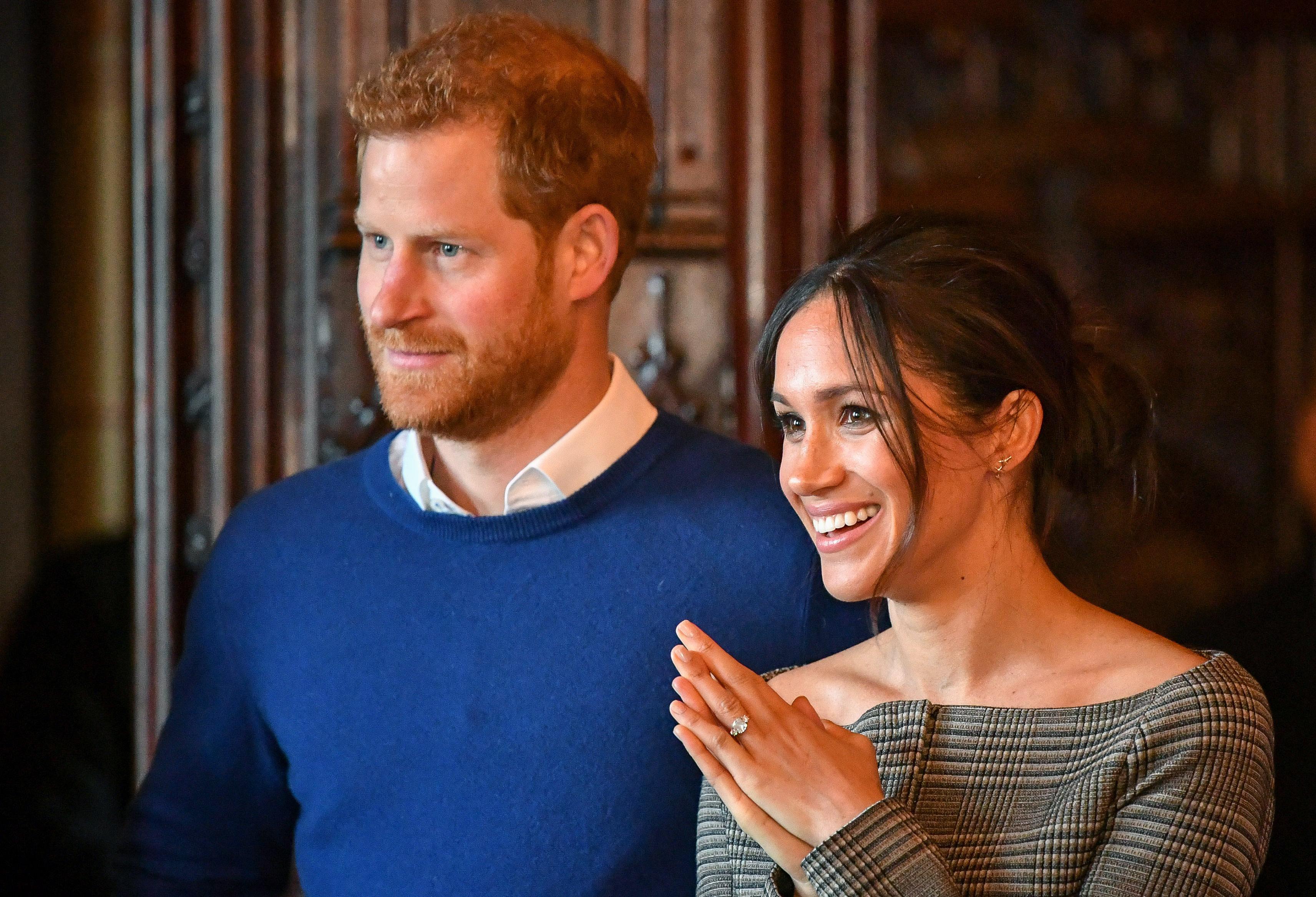 meghan markle in verde si printul harry cu un pulover albastru