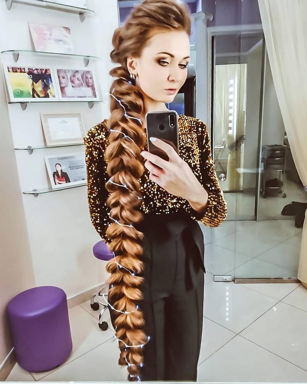 Daria Gubanova cu părul prins în coadă împletiită, îmbrăcată în negru
